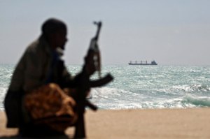 An armed Somali pirate sits along the coastline of Hobyo town in northeastern Somalia on January 7, 2010. (Mohamed Dahir-AFP-Getty)