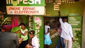 Residents transfer money using the M-Pesa banking service at a store in Nairobi, Kenya